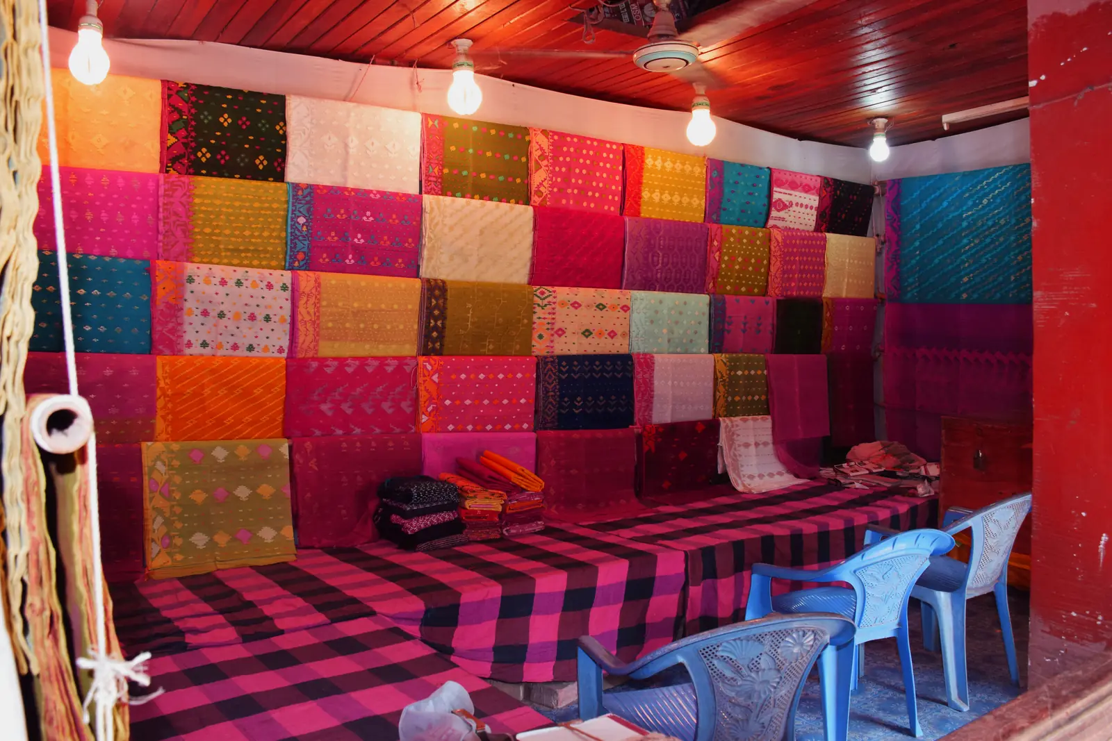 A Jamdani saree shop in Sonargaon, Bangladesh, folded saris stacked from floor to ceiling.