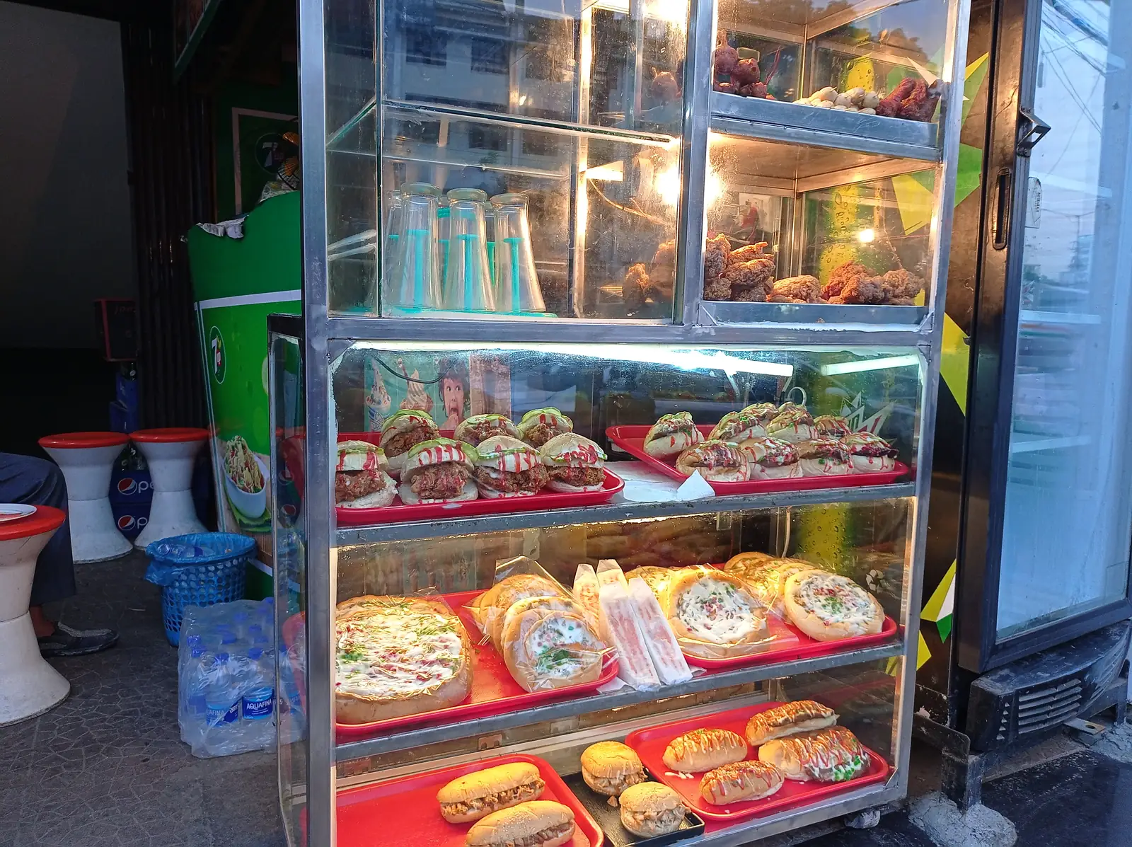 A fast-food street shop near Mirpur 10 in Dhaka, food laid out along the counter for customers.